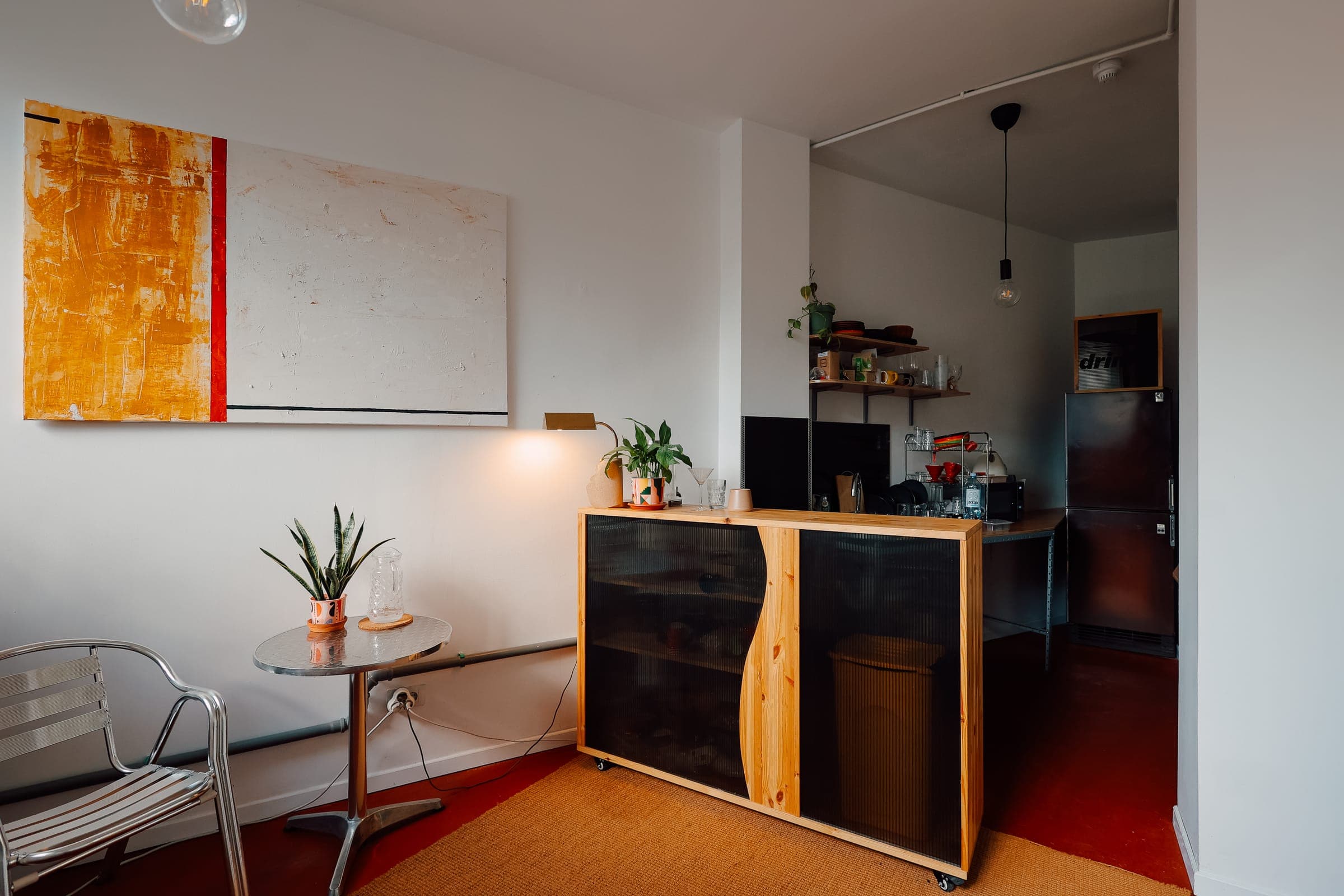 Shared kitchen and common area at SENSE—S.SPACE with custom cabinetry and abstract art