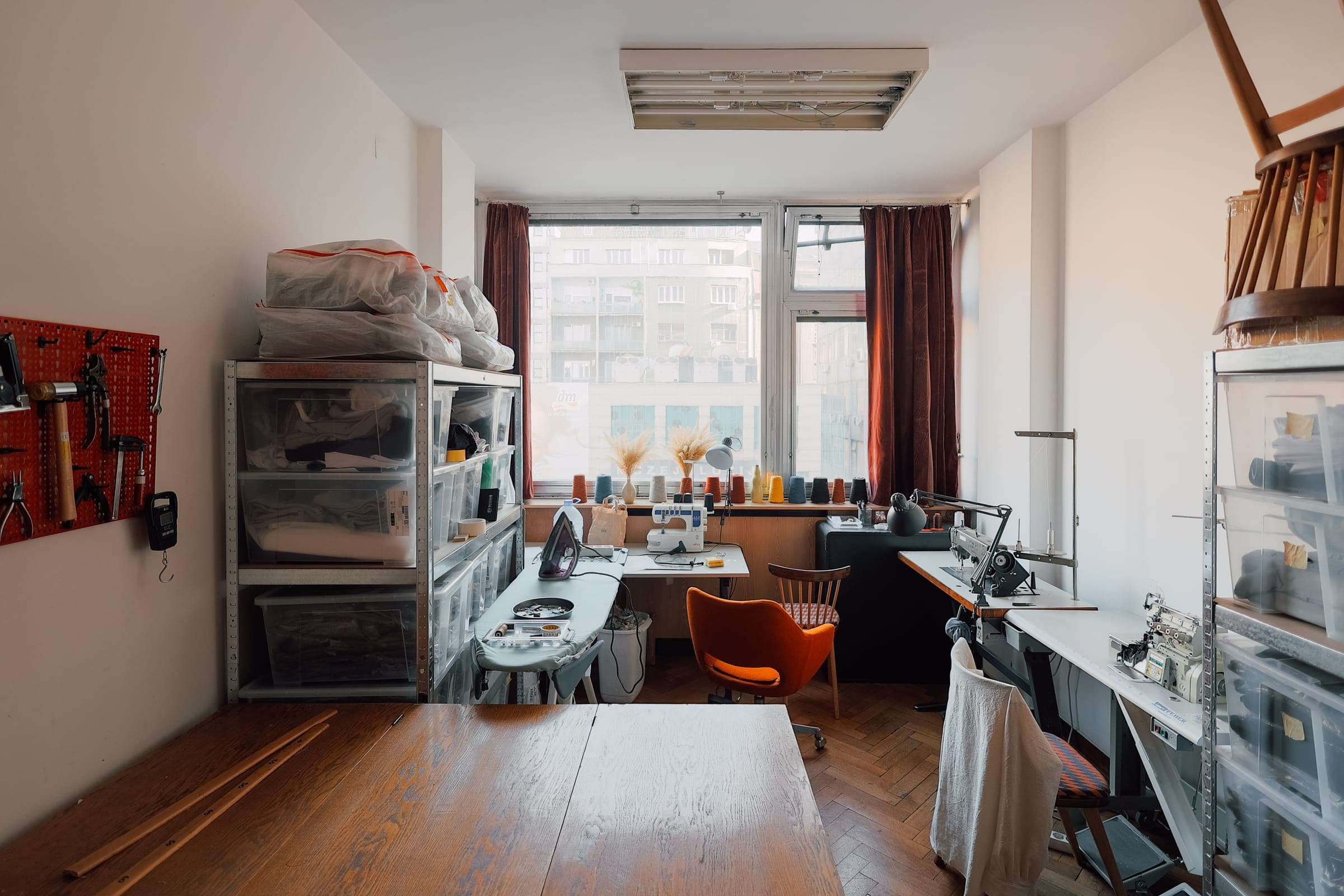Sewing studio at SENSE—S.SPACE with industrial machines, ironing station, and fabric storage